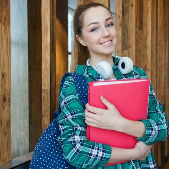 woman standing in hallway while holding book