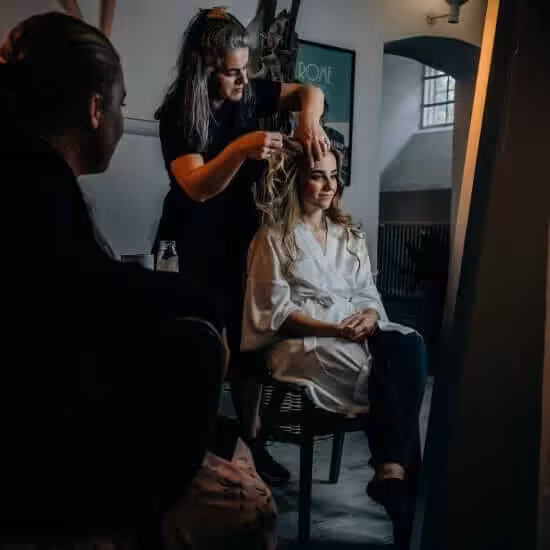 hairstylist fixing her client s hair