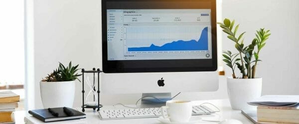 silver imac displaying line graph placed on desk