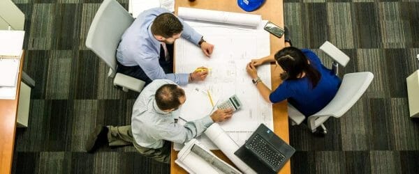 three people sitting beside table