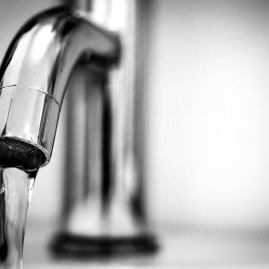 macro photography of a stainless steel faucet