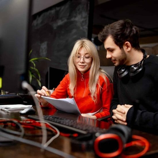 two colleagues are discussing issues modern office man woman colleagues are sitting table with computer business plan