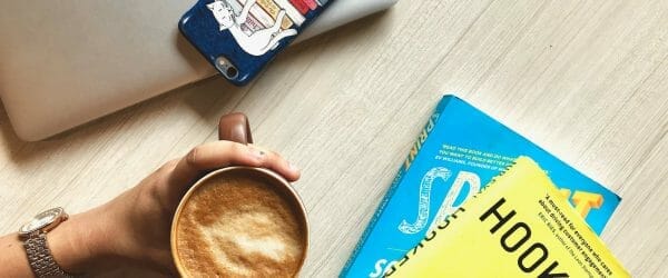 person holding brown ceramic coffee mug