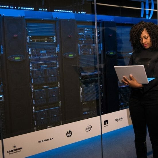 software engineer standing beside server racks