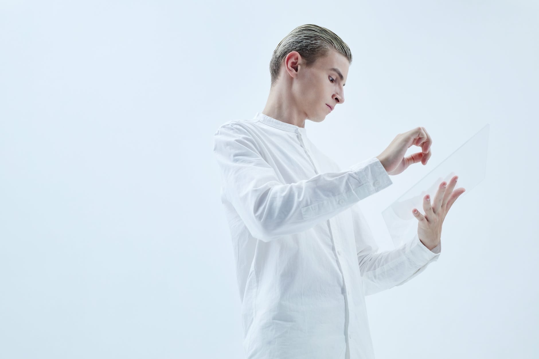 a low angle shot of a man in white long sleeves holding a clear glass