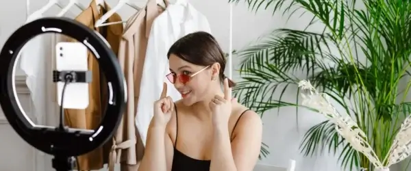 a woman showing her sunglasses to a video recording