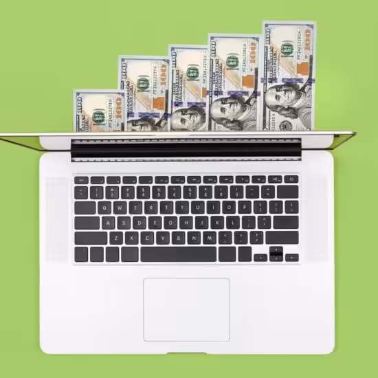 a laptop with money on it