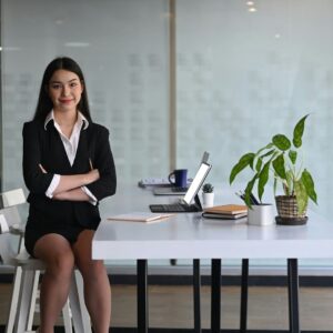 Businesswoman sitting confidently at desk.