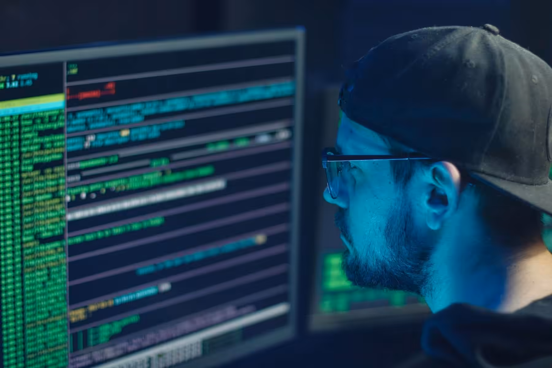 Person coding with multiple computer screens.