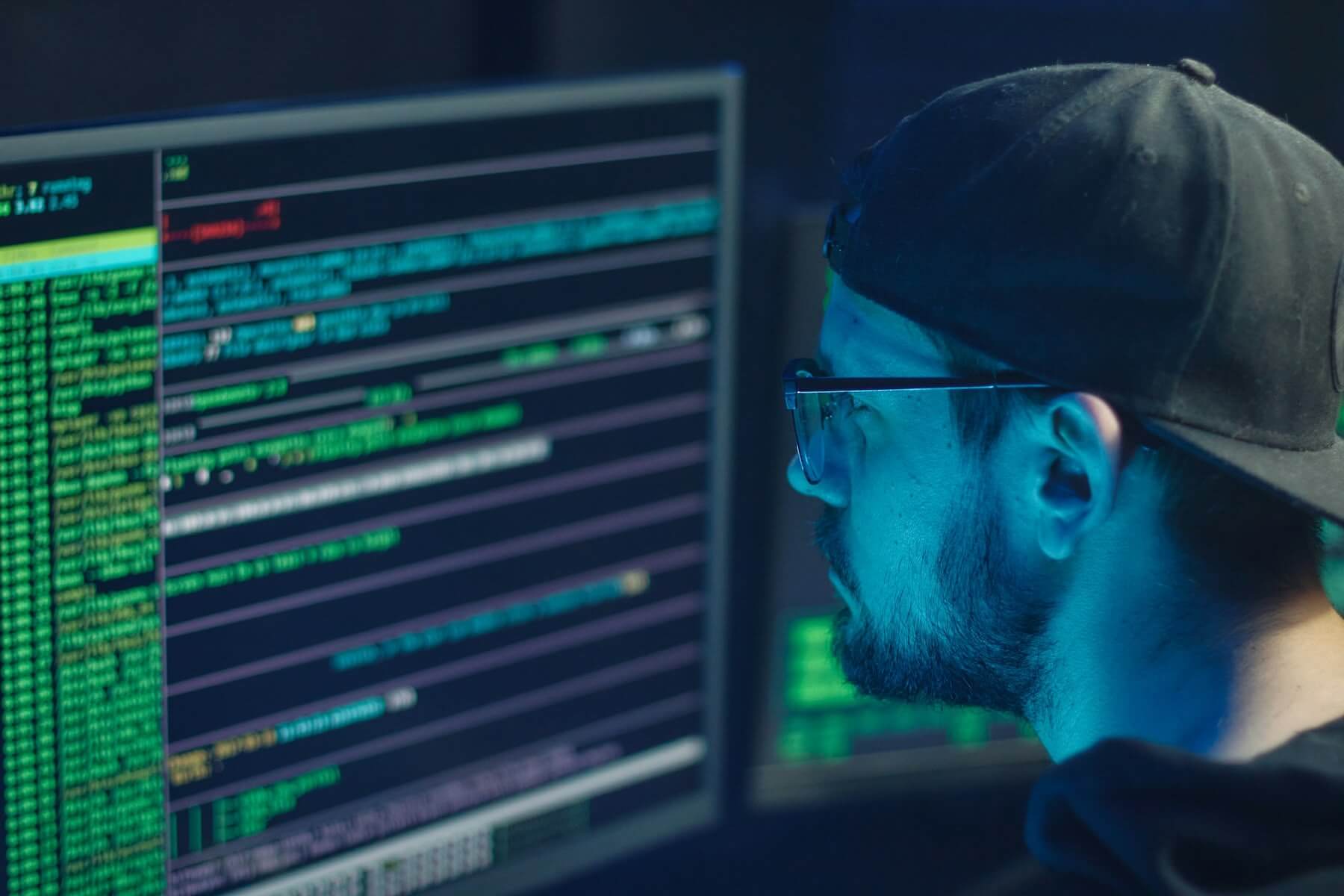 Person coding with multiple computer screens.
