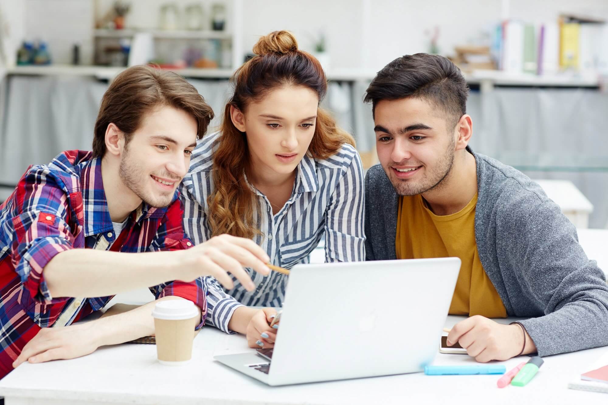 Three students collaborating on laptop
