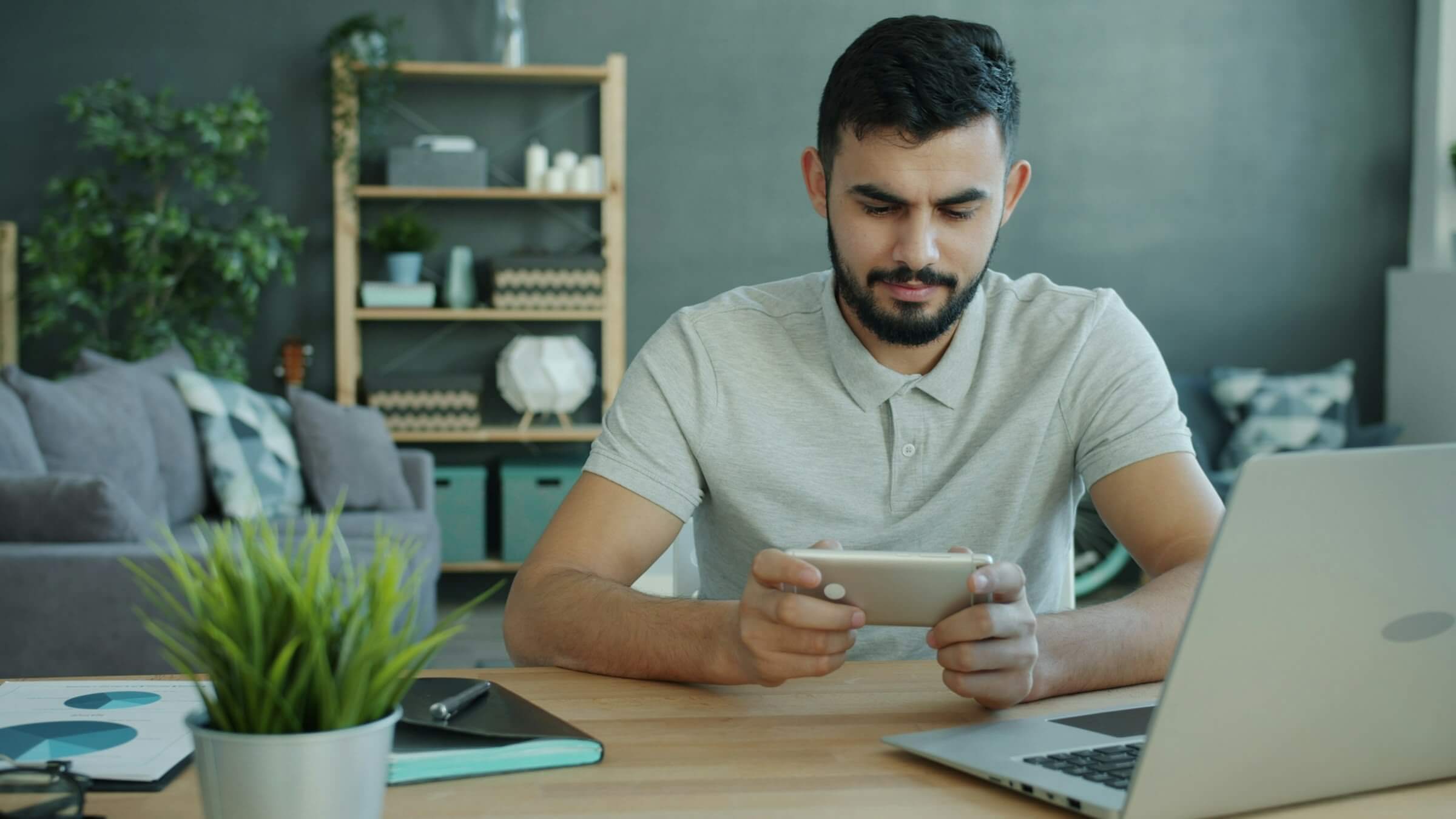 Happy Moddle Eastern man is playing video game
