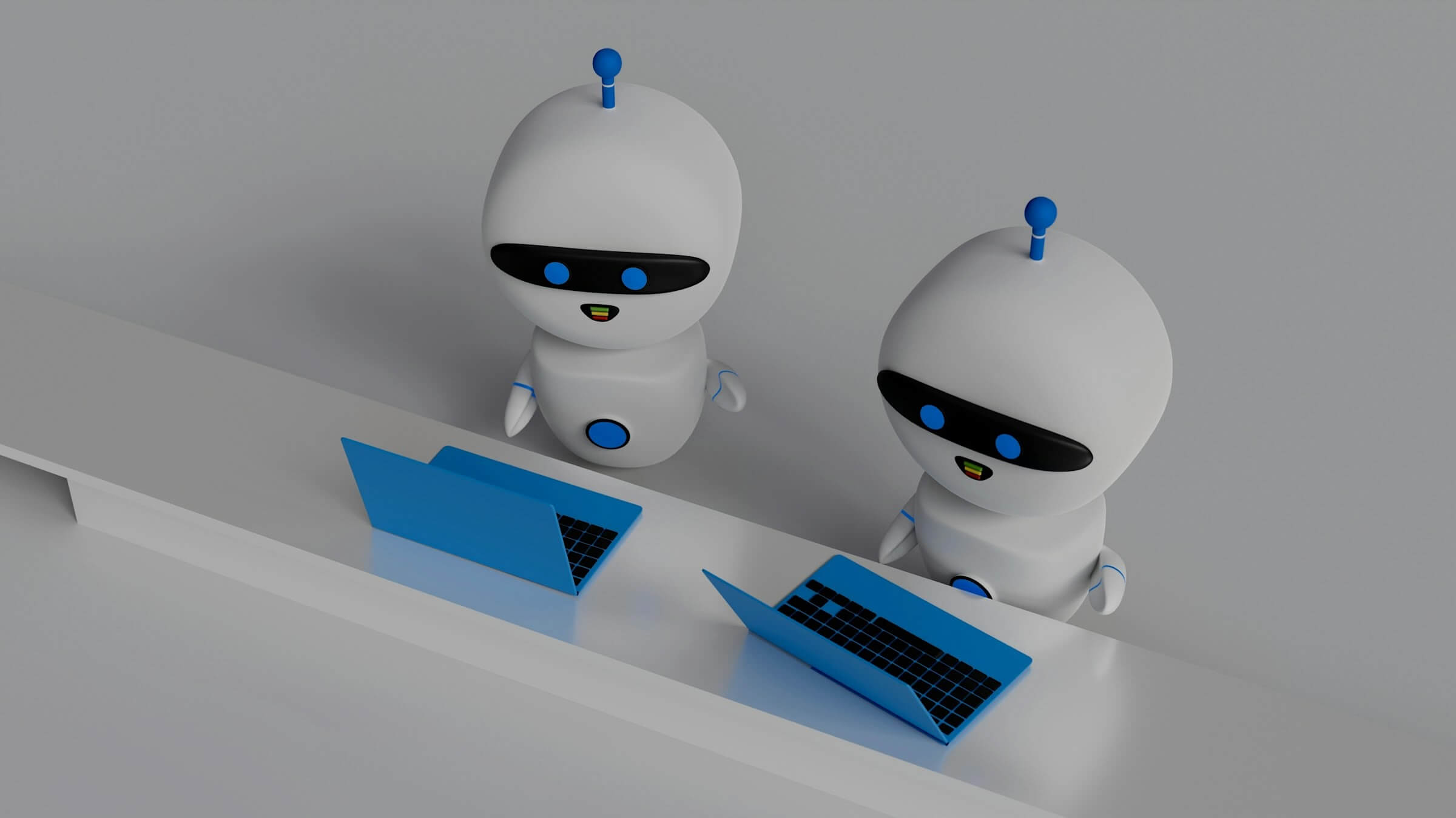 Two robots working on laptops