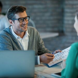 happy-businessman-talking-to-his-colleague-while-going-through-financial-reports